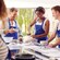 A group of people in aprons around a counter during a cooking class